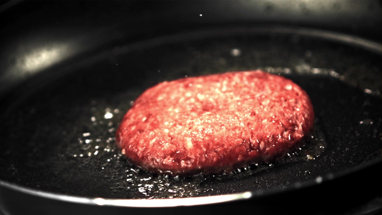 Raw Burger Patty Sizzling and Frying in a Hot Pan