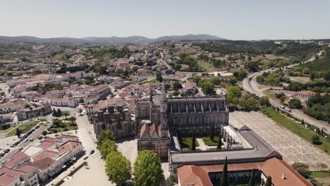 batalha city rooftops and majestic historical monastery, aerial drone orbit view