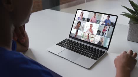 African-american-woman-talking-on-video-conference-on-laptop-with-office-colleagues-at-home