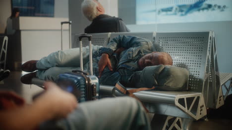 tired traveler sleeping in airport lounge