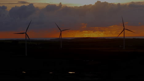 Turbinas-Eólicas-En-Armonía-Con-La-Naturaleza-Contra-Hermosos-Cielos-Coloridos-De-Puesta-De-Sol,-Tiro-Estático