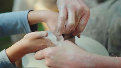 the master potter teaches the child how to make pots concept - transfer of experience training 4k sl