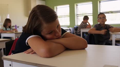 chica con la cabeza en el escritorio en la clase
