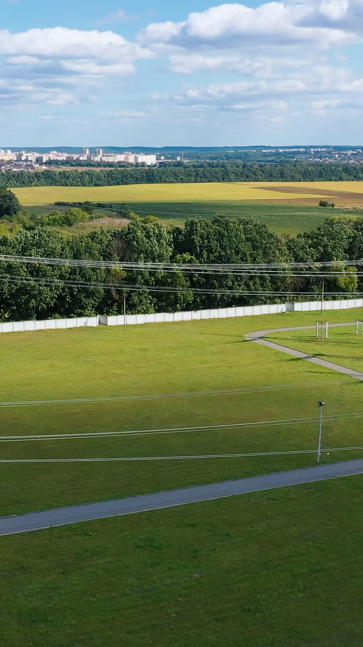Electric transmission towers on a green field. Power lines supply with wires. High voltage electric pylons in the countryside. Vertical video