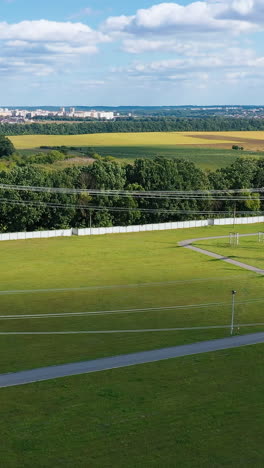 electric transmission towers on a green field. power lines supply with wires. high voltage electric pylons in the countryside. vertical video