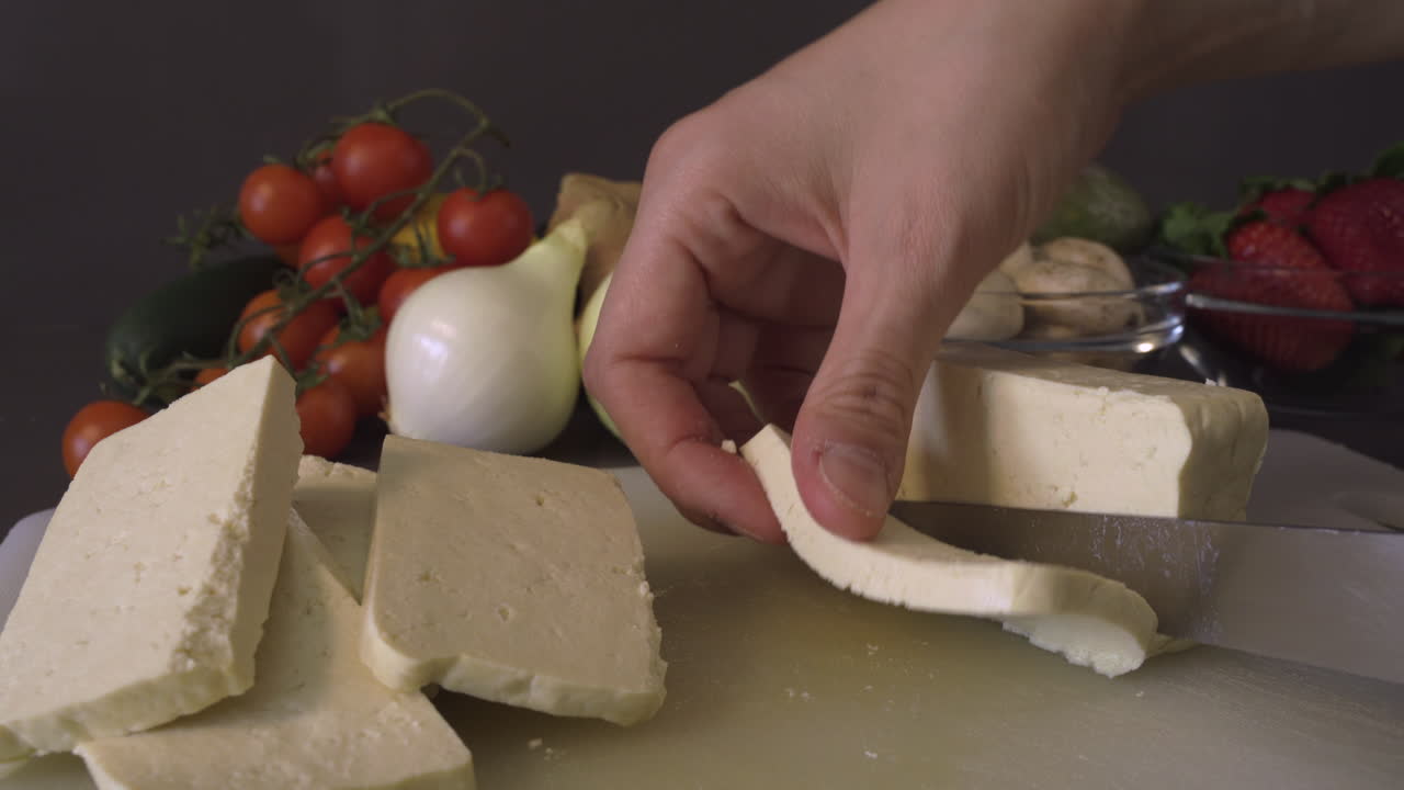 Slicing tofu for a delicious vegan dish - close up