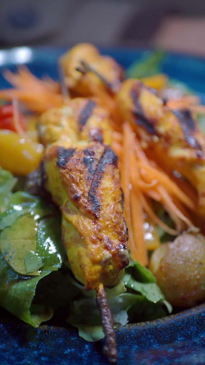 Primo piano di spiedini di pollo grigliati con insalata fresca e patate