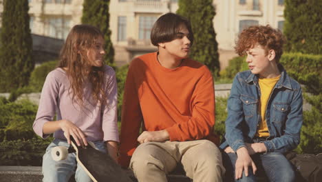 a red haired teenager tells a very funny story to his two teenage friends