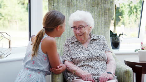 Granddaughter-Sitting-And-Talking-With-Grandmother-During-Visit-To-Retirement-Home