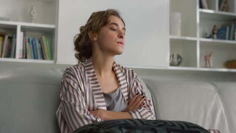 una chica molesta pensando en problemas en pijama en primer plano. una mujer hermosa posando en el sofá.