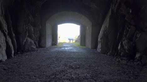 walking forwards in dark cave with a bright opening in the middle