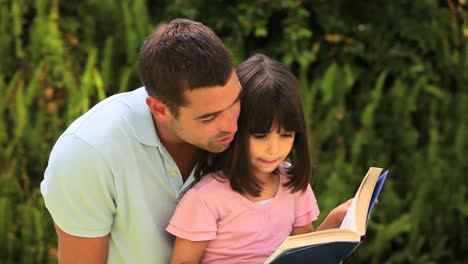 padre leyendo a su hija pequeña