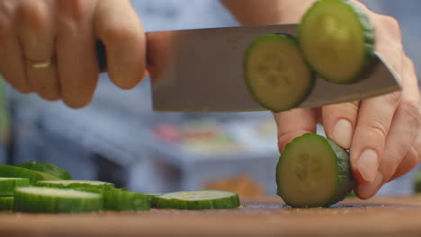 Cut-a-knife-on-a-wooden-board-closeup-cucumbers-in-the-kitchen.-shred