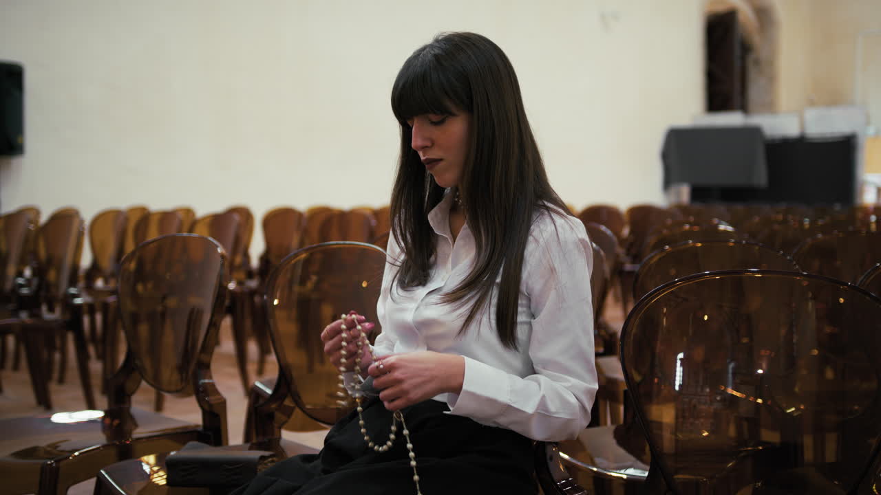 Woman Using Rosary To Pray In The Church