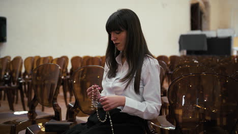 woman using rosary to pray in the church