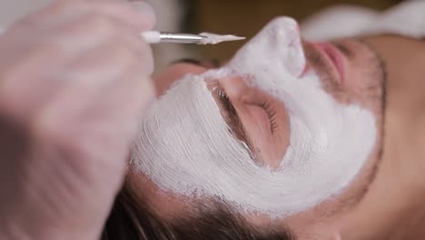 man receiving facial mask treatment
