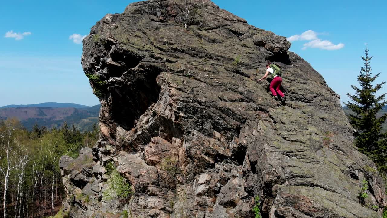 una joven exitosa sube a la cima de la montaña.