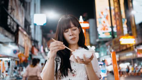 young asian woman eating thai traditional dessert street food at yaowarat bangkok chinatown in bangkok