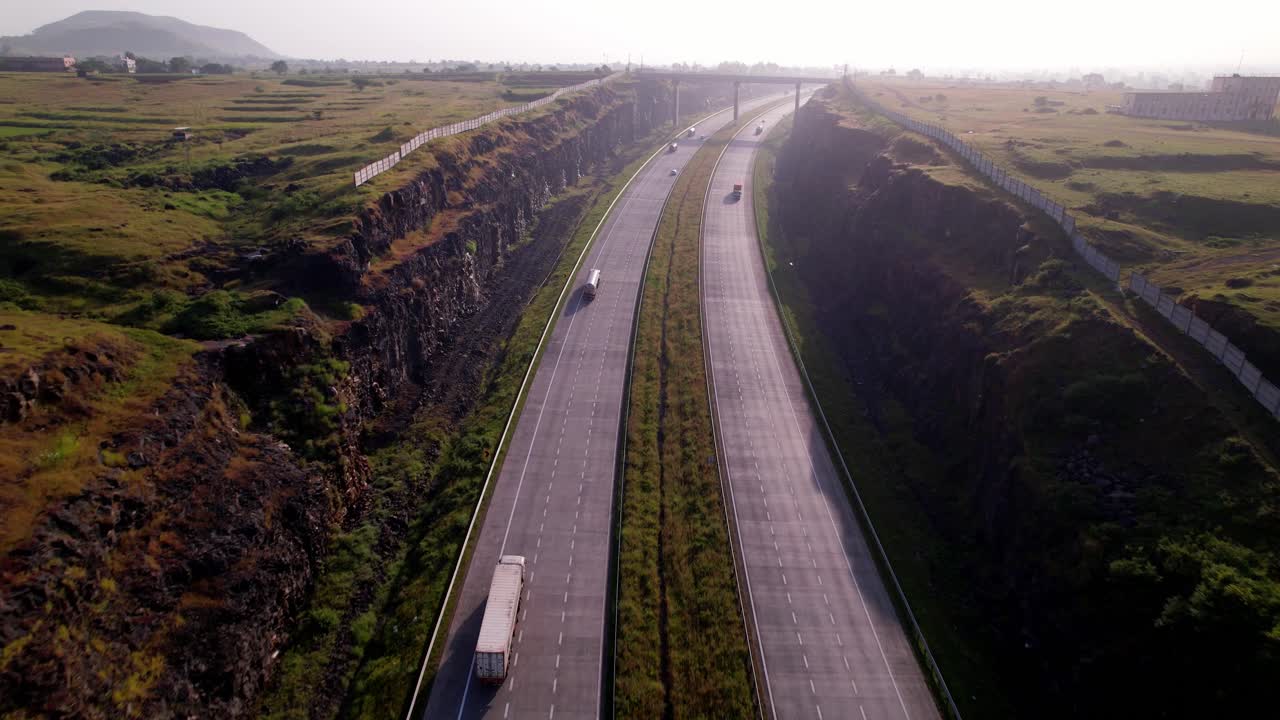 Mumbai Nagpur Expressway through western ghats green corridor under hazy sky, bridge to traverse natural landscapes and waterways, Maharashtra, Drone shot