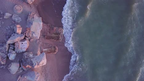 aerial birdseye view of abandoned seaside fortification buildings at karosta northern forts on the beach of baltic sea in liepaja, latvia, calm sea, golden hour, wide angle point of view drone shot