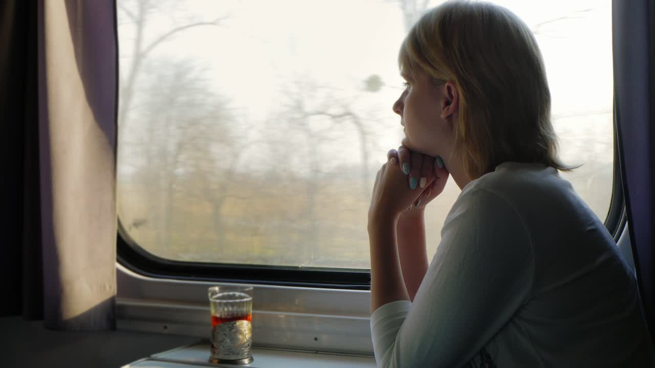A Comfortable Trip A Young Woman Is Traveling On A Train Beside Her There Is A Cup Of Tea In A Cup H