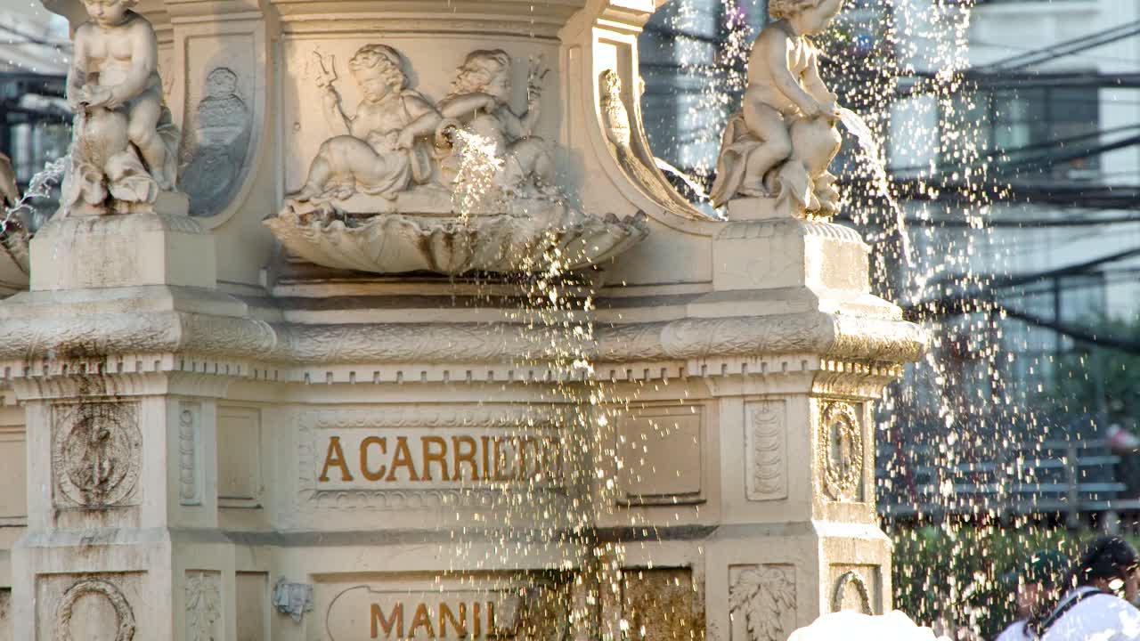 Et detaljeret nærbillede af vand, der sprøjter fra den udsmykkede stenfontæne Carriedo