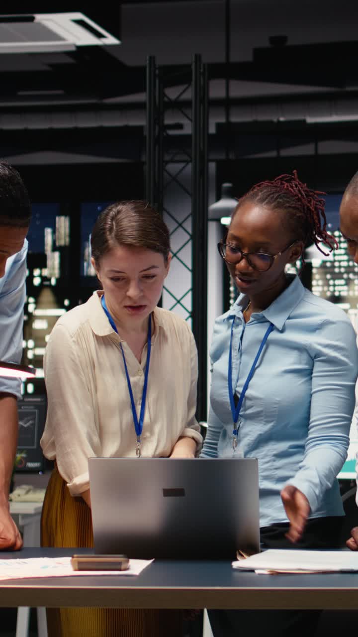 Vertical Video Portrait of associates team collaborating in office environment at night