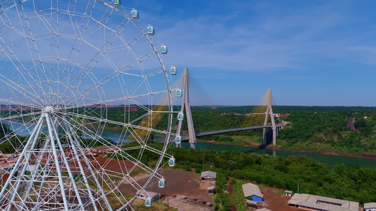 aerial view of the ferris wheel in Foz do Iguaçu with the Brazil-Paraguay Integration Bridge in the background