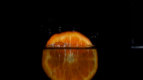 Hochgeschwindigkeitskamera-Zeitlupen-Rückwärtsvideo-Einer-Orangenscheibe,-Die-Ins-Wasser-Spritzt