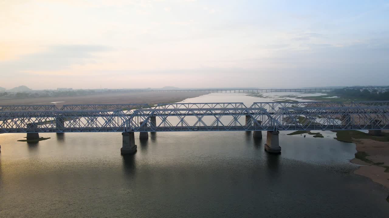 Aerial drone shot capturing the essence of Vijayawada in the early morning, with the sun rising over a misty skyline.