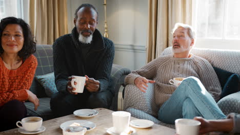 Group-Of-Middle-Aged-Friends-Meeting-Around-Table-In-Coffee-Shop