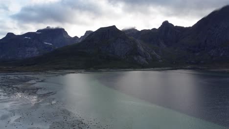 Flying-over-the-coast-of-Norway,-Lofoten-looking-at-the-mountains-in-clouds-in-the-background