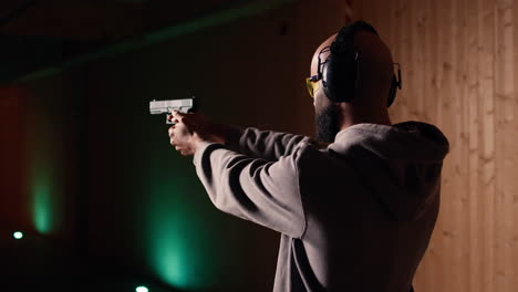 man shooting targets with pistol, learning to operate handgun in close quarters