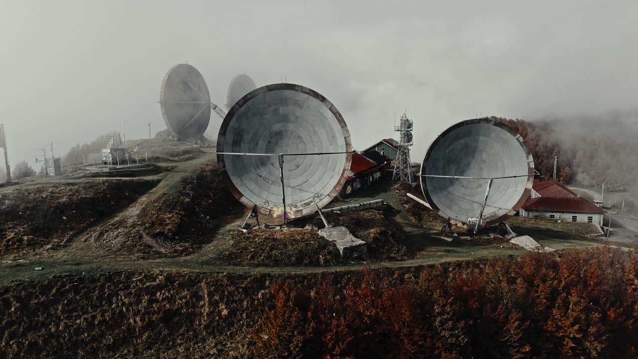 Aerial View of Large Satellite Dishes on a Foggy Mountain Top