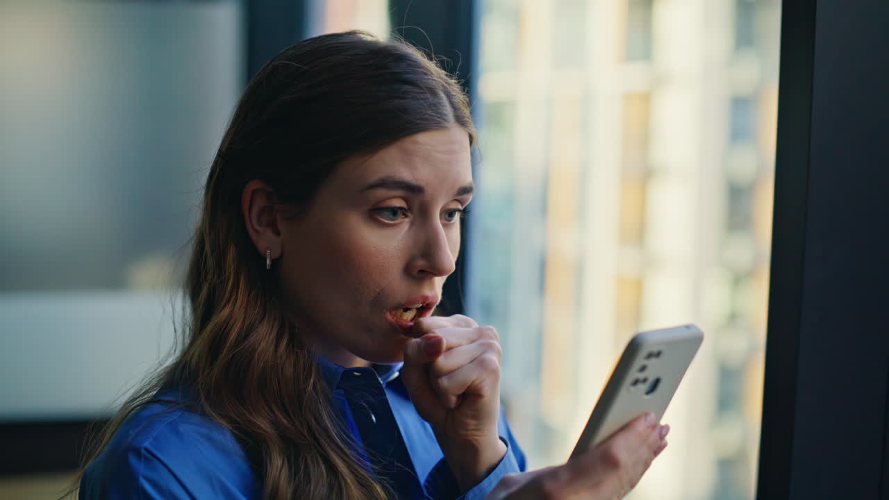 Frustrated woman looking smartphone reacting bad message at buro office closeup