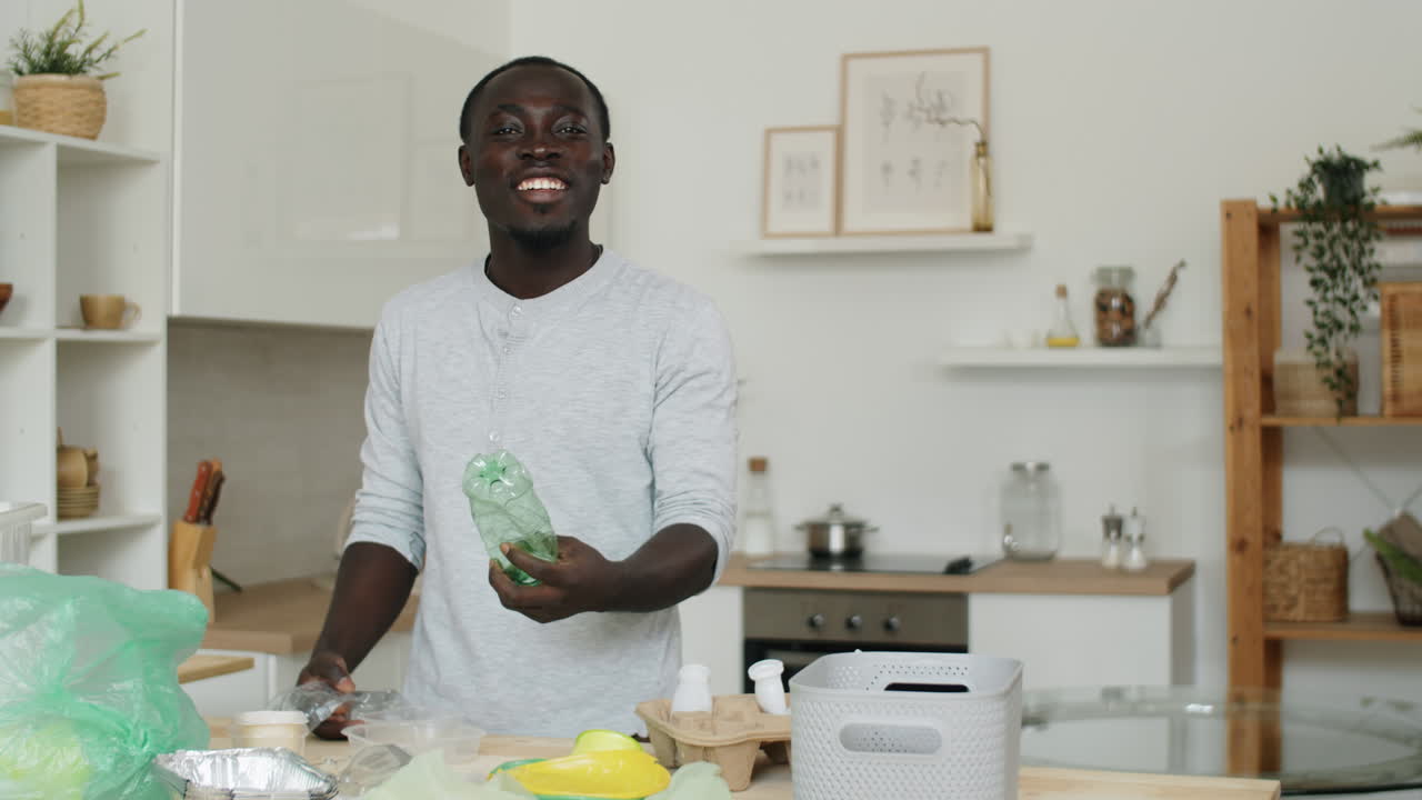 Portrait of Cheerful Black Man Sorting Plastics at Home