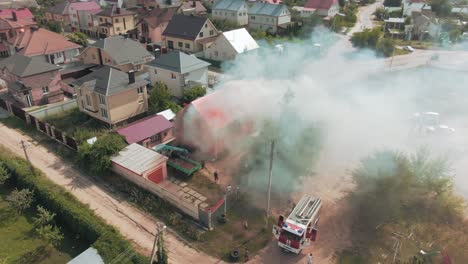 aerial view of house fire with fire truck and firefighters