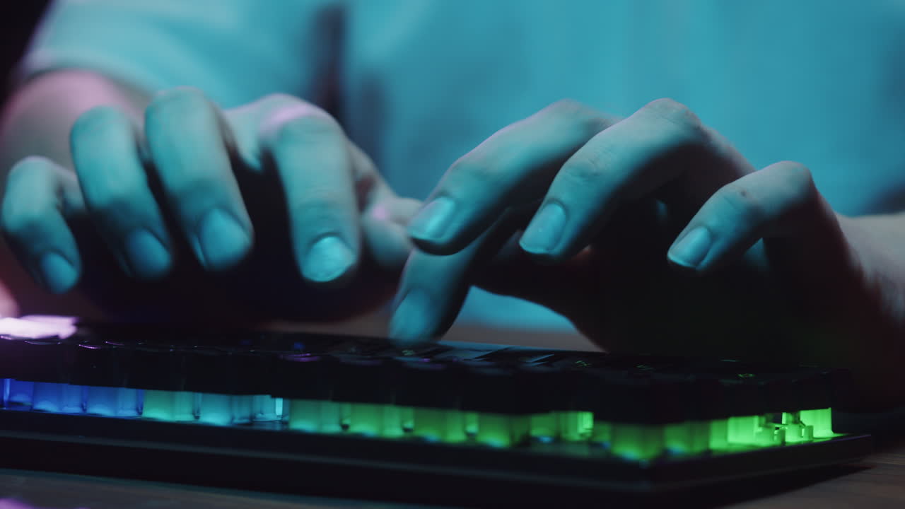 Nærbillede af hænder, der taster på et RGB-gamingtastatur