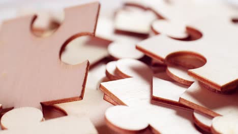 a closeup of jigsaw puzzle pieces placed on a turning table revealing pieces exposed to light and creating shadows.