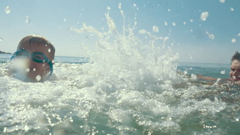 boy spinning around and splashing in the sea