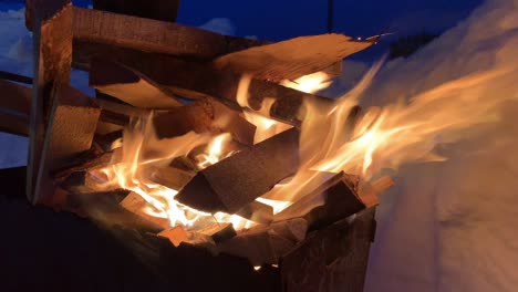 la leña apilada en la parrilla arde bien y brillantemente por la noche.