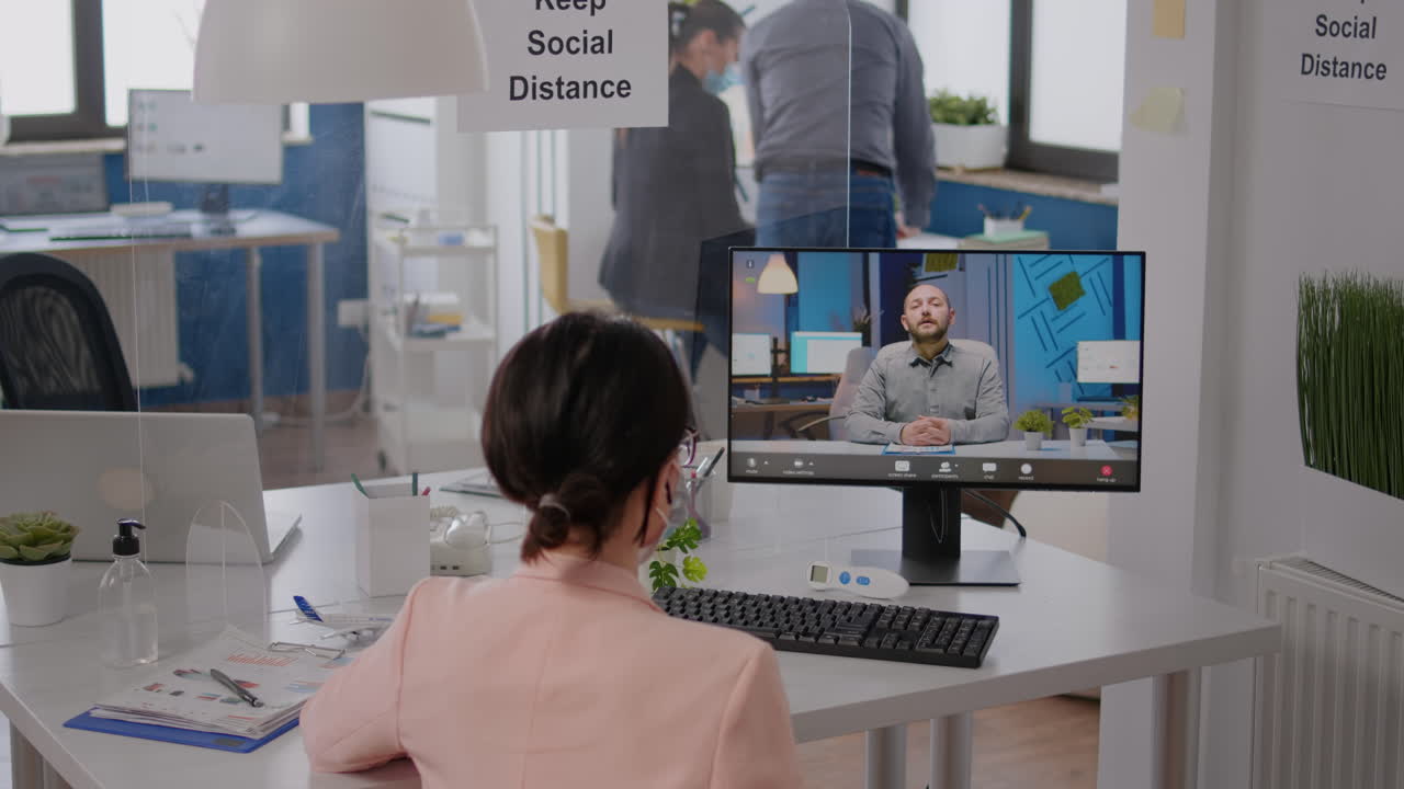 새로운 정상적인 회사 사무실에서 책상 테이블에 앉아있는 프리랜서