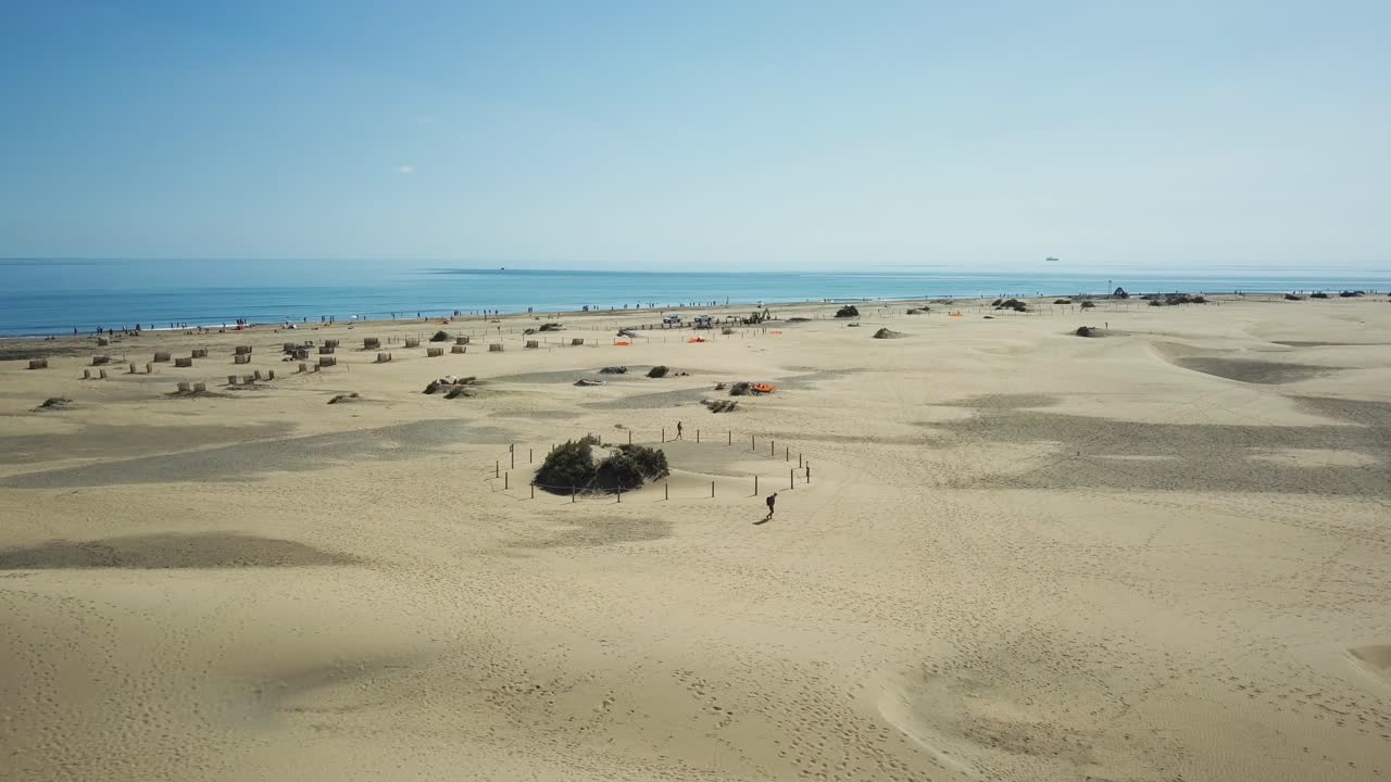 4K aerial footage of a man walking in the desert - Fantastic view of the Maspaloma nature reserve and also on the atlantic ocean.