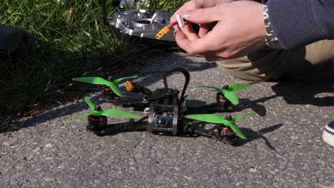 close-up, caucasian drone pilot mounts battery on a fpv racing drone