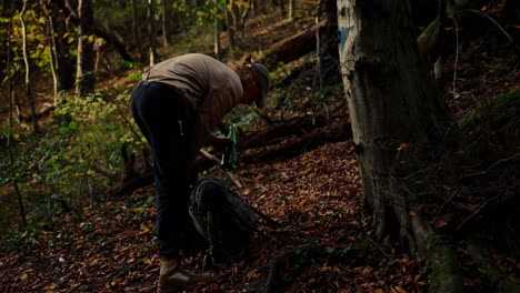 hiker in forest packing bottle in his backpack, continue his journey, autumn, dürnstein