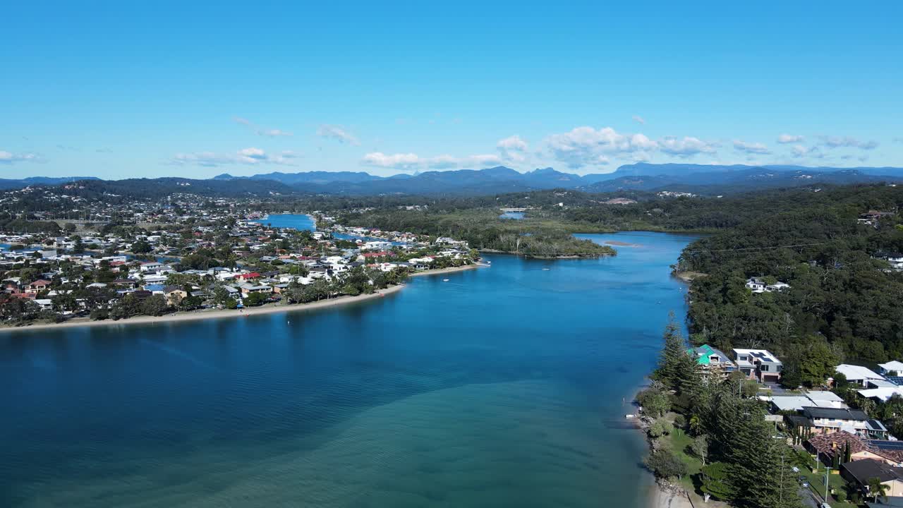 vista alta de drones del arroyo tallebudgera y el estuario con un telón de fondo montañoso en la costa dorada de australia