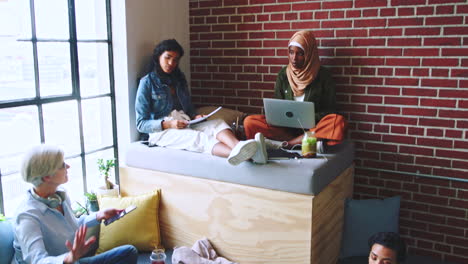 grupo diverso de mujeres trabajando y relajándose en un espacio de oficina moderno