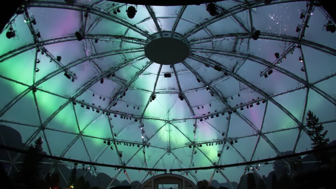 An Enchanting View of a Geodesic Dome Illuminated with Mesmerizing Colors, Capturing the Atmosphere of a Unique Venue Amidst a Mystical Night Sky
