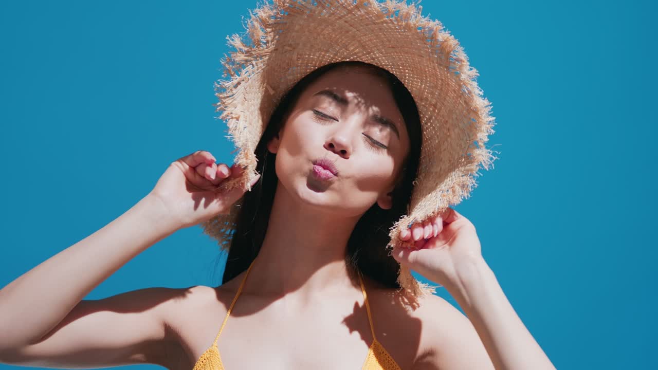 모자를 입은 젊은 여성 모델이 빛을 즐기고 키스를 니다.