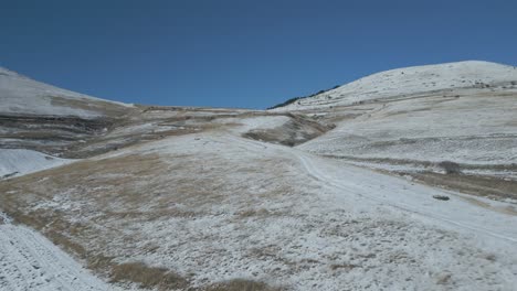 a drone footage over castelluccio - italy during winter period with snow